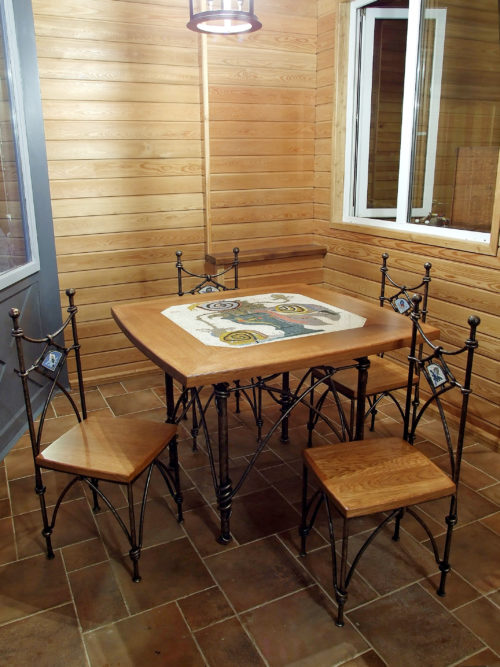 Комплект мебели: стол из массива с кованым основанием и четыре стула на кованом каркасе.
